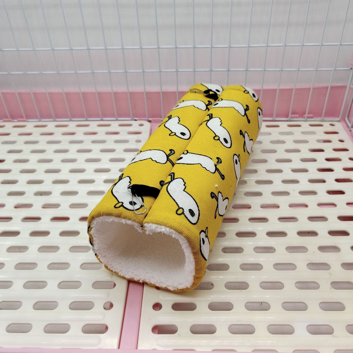 Cozy Critter Tunnel in gele stof met witte diertjes op de grond